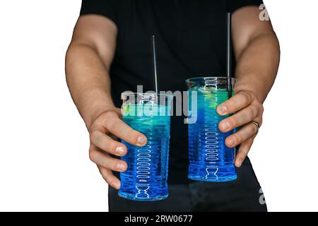 Le mani del barista servono 2 cocktail alcolici con sciroppo blu laguna blu su sfondo bianco isolato. Foto Stock