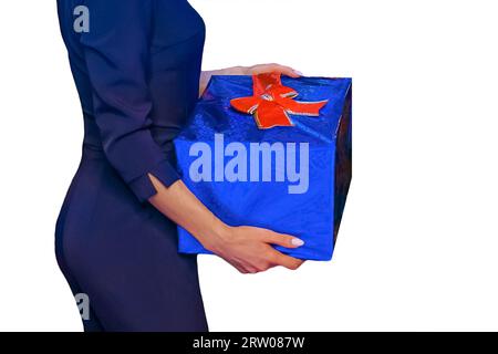 Una ragazza tiene una scatola in un film regalo blu regalo di Capodanno sullo sfondo bianco isolato. Foto Stock