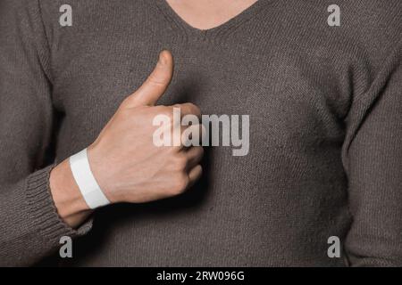 La mano di un uomo mostra classe con un pollice su fico. Foto Stock