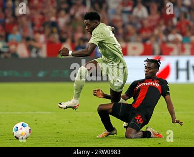 Monaco, Germania. 15 settembre 2023. Alphonso Davies (L) del Bayern Monaco vies con Jeremie Frimpong di Leverkusen durante una partita di calcio della Bundesliga di prima divisione tedesca a Monaco di Baviera, in Germania, 15 settembre 2023. Credito: Philippe Ruiz/Xinhua/Alamy Live News Foto Stock