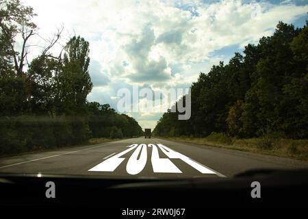 L'anno 2024 è scritto sulla strada sull'autostrada, vista da un'auto di guida su strada in Ucraina, felice anno nuovo 2024 Foto Stock