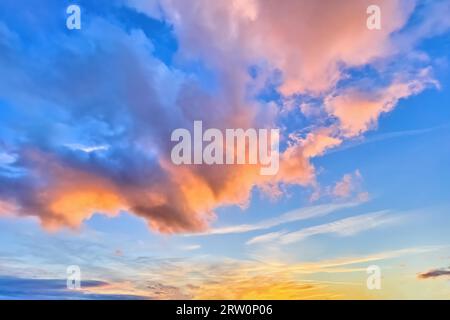 Le nuvole di Altocumulus sono illuminate dal sole che tramonta con una calda luce colorata, in Germania Foto Stock