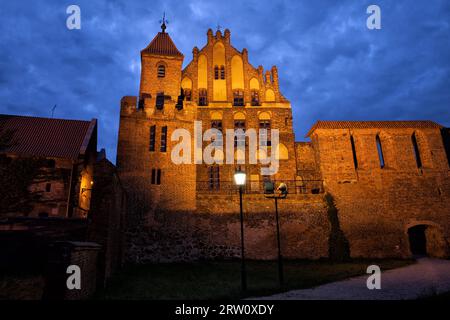 Tribunale cittadino di notte, torre di sentinella e mura cittadine a Torun, Polonia, ex residenza estiva della Confraternita di San George, gotico medievale Foto Stock