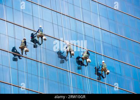 Seoul, Corea del Sud, 25 ottobre 2014: I lavoratori puliscono le finestre come squadra su un grattacielo nel centro di Seoul, Corea del Sud Foto Stock