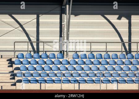 Tribuna con gusci blu per i posti a sedere in uno stadio sportivo Foto Stock