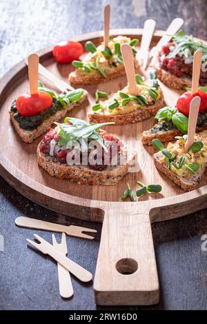 Bruschetta fatta in casa con pomodoro e pesto per colazione su un piatto da portata. Foto Stock