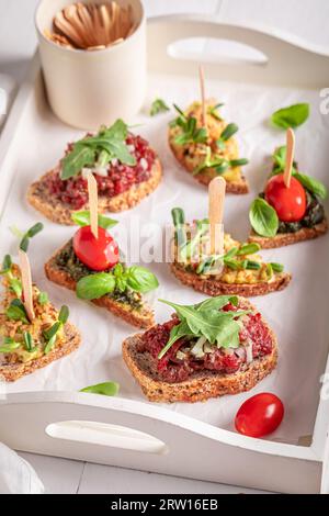 Bruschetta fresca con pomodoro e pesto per colazione su un piatto da portata. Foto Stock