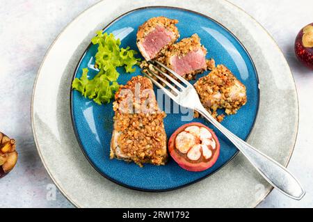 Piatto di bistecca di tonno al forno in panico con mangostani. Spianatura piatta. Foto Stock