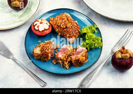 Bistecca di tonno al forno in una noce con mangostani. Frutti di mare. Foto Stock