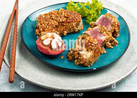 Bistecca di tonno al forno in una noce con mangostani. Frutti di mare. Foto Stock