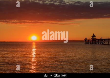 Clevedon Pier in una serata luminosa e colorata mentre il sole sta per tramontare sulla costa gallese Foto Stock