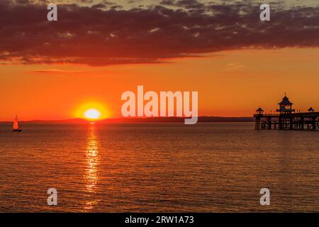 Clevedon Pier in una serata luminosa e colorata mentre il sole sta per tramontare sulla costa gallese Foto Stock