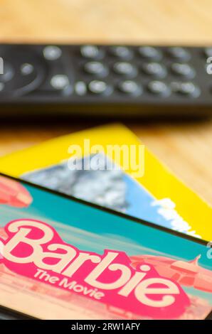 Madrid, Spagna 09 15 2023: Messa a fuoco selettiva, Barbie il logo del film visualizzato su uno smartphone e un telecomando tv Foto Stock