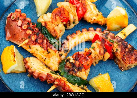 Spiedino di pesce. Polpo o calamari grigliati su uno spiedino Foto Stock