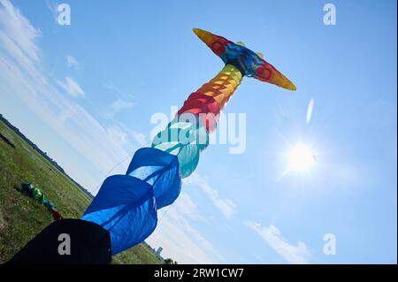 Berlino, Germania. 16 settembre 2023. A Tempelhofer Feld, un lungo aquilone colorato decolla verso il sole nel cielo blu della tarda estate al decimo Festival degli aquiloni giganti. Crediti: Annette Riedl/dpa/Alamy Live News Foto Stock