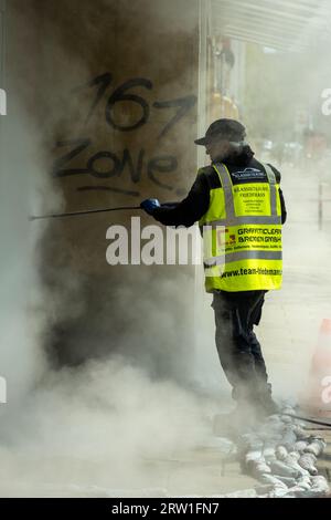 20.04.2023, Germania, Brema, Brema - l'azienda speciale rimuove i graffiti sgradevoli da una parete della casa con un pulitore ad alta pressione (HDR), acqua con che Foto Stock