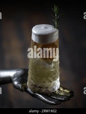 Dettaglio cocktail con schiuma, paglia e fette d'arancia disidratate Foto Stock