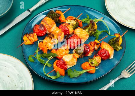 Pesce spiedato con verdure su spiedini di legno. Spiedini di pesce con verdure. Foto Stock