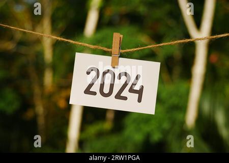 2024 su carta appesa alla corda di iuta. Addio 2023 benvenuto felice anno nuovo 2024 Concept. Foto Stock