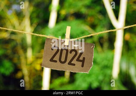 2024 su carta appesa alla corda di iuta. Addio 2023 benvenuto felice anno nuovo 2024 Concept. Foto Stock