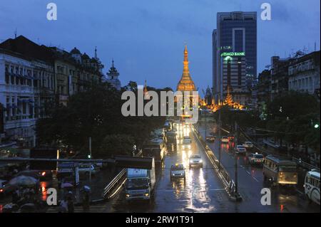 29.07.2013, Myanmar, Yangon, Yangon - Vista sopraelevata del centro della città durante la stagione delle piogge con la Pagoda di Sule illuminata sullo sfondo. La Foto Stock