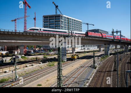 06.09.2023, Berlino, Germania, Europa - il traffico ferroviario attraversa un ponte di fronte ad un cantiere con gru all'Europacity di Moabit. Foto Stock