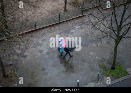 11.04.2023, Germania, Berlino, Berlino - Europa - le persone con ombrelloni camminano lungo un marciapiede bagnato nel quartiere di Charlottenburg-Wilmersdorf durante l'AP Foto Stock