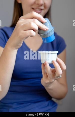 Primo piano di una ragazza che tiene il supporto del cerotto di monitoraggio del glucosio flash prima di applicarlo al braccio Foto Stock