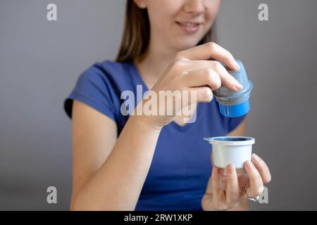 Primo piano di una ragazza che tiene il supporto del cerotto di monitoraggio del glucosio flash prima di applicarlo al braccio Foto Stock