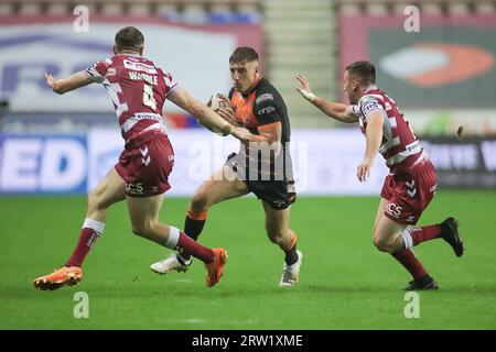 Wigan, Regno Unito. 15 settembre 2023. Alex Mellor di Castleford corre contro Joe Wardle e Harry Smith di Wigan *** durante il Betfred Super League match tra Wigan Warriors e Castleford Tigers al DW Stadium di Wigan, in Inghilterra, il 15 settembre 2023. Foto di Simon Hall. Solo per uso editoriale, licenza necessaria per uso commerciale. Nessun utilizzo in scommesse, giochi o pubblicazioni di un singolo club/campionato/giocatore. Credito: UK Sports Pics Ltd/Alamy Live News Foto Stock