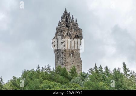 Stirling, Scozia, Regno Unito - 19 agosto 2023 - guardando verso l'alto il Monumento di Wallace in Scozia contro un cielo grigio lunatico Foto Stock