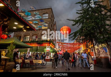 Londra, Regno Unito: Incrocio tra Gerard Street e Macclesfield Street a Chinatown di Londra. Lanterne rosse cinesi e ombrelloni colorati pendono sopra la strada. Foto Stock