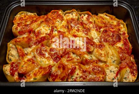 Conchiglione tradizionale ripieno di ricotta e pomodori secchi con rucola Foto Stock