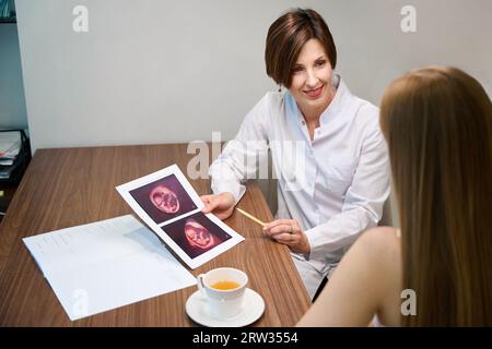 Due donne insieme guardano le immagini ecografiche fetali Foto Stock