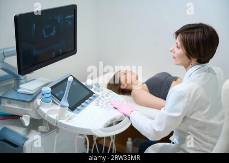 Uzist esegue la procedura di ecografia del feto di una donna incinta Foto Stock