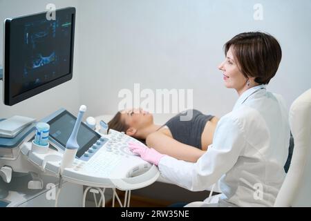 L'uzista femminile esegue la procedura ecografica per il feto di una donna incinta Foto Stock