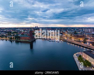 Vista aerea della città serale. Infrastrutture di trasporto e luoghi di interesse famosi al tramonto. Famoso municipio sul lungomare. Stoccolma, Svezia Foto Stock