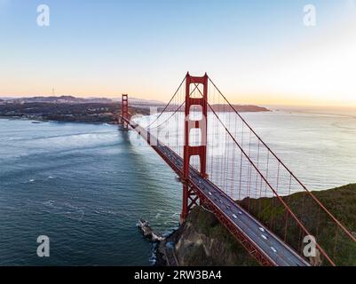 Vista aerea del Golden Gate Bridge che attraversa il corso d'acqua. Lungo ponte sospeso e veicoli che passano sopra la baia marina. San Francisco, California, USA Foto Stock
