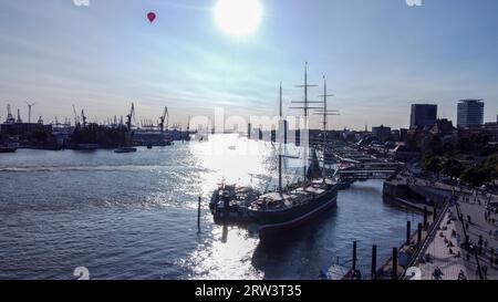 Barca a vela molto grande vicino alla riva del fiume Norderelbe ad Amburgo il sole splende nell'acqua e nel punto di vista di skyюВкщту, così le persone camminano sul Foto Stock