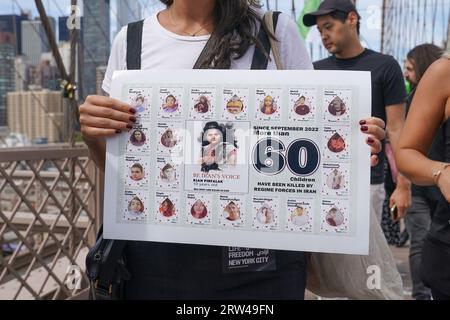 Centinaia di persone si radunano e marciano attraverso il ponte di Brooklyn a New York il 16 settembre 2023 in occasione dell'anniversario dell'omicidio di Mahsa Jina Amini in Iran dopo Carest per aver presumibilmente non indossato l'hijab Foto Stock