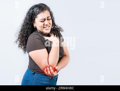 Persone con dolore al gomito isolate. Donna con dolore al gomito causato da reumatismi. Giovane ragazza che soffre di gomito di crampi isolato Foto Stock