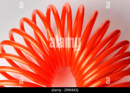 Tubo flessibile dell'aria in plastica a spirale arancione rosso utilizzato per utensili pneumatici Foto Stock