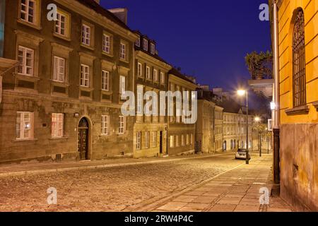 La strada acciottolata di Mostowa e le case a schiera di notte nella città nuova, Varsavia, Polonia Foto Stock