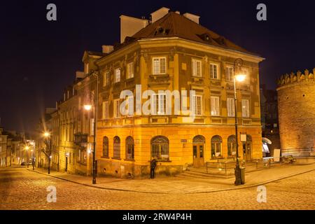 Case e angolo tra le strade acciottolate Mostowa e Nowomiejska di notte nella città nuova (vicino alla città vecchia) di Varsavia, in Polonia Foto Stock