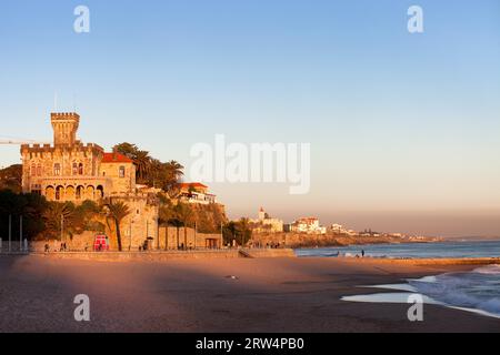 Tranquillo scenario sull'Oceano Atlantico, la spiaggia di Tamariz, dominata da un castello al tramonto nella località turistica di Estoril, in Portogallo Foto Stock