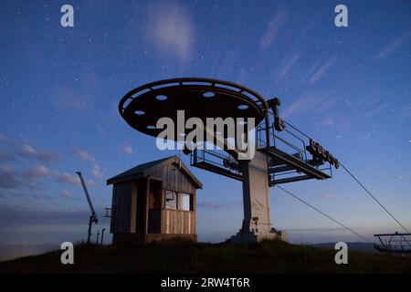 Un solitario impianto di risalita e un edificio sotto un cielo stellato estivo sul Monte Buller, nell'alta campagna vittoriana, Australia Foto Stock