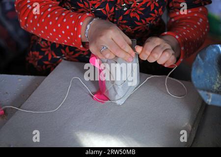 Le famiglie che lavorano stanno confezionando caramelle croccanti di arachidi in un laboratorio di famiglia. Foto Stock