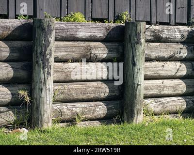 Parete di contenimento palo semitonda in legno a sbalzo. Per siti residenziali. Foto Stock