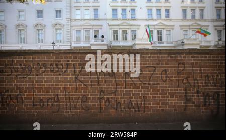 Londra, Regno Unito. 16 settembre 2023. Prima della protesta, i graffiti realisti vengono spruzzati sul muro fuori dall'ambasciata iraniana. La protesta segna il primo anniversario della morte di Mahsa Amini 22, che è stato arrestato dalla polizia della moralità in Iran dopo aver detto che indossava il suo hijab in modo errato. Amini e' stata portata in un centro di detenzione dove e' collassata ed e' morta. La sua morte e la morte di altri a seguito di una repressione in Iran hanno ispirato il movimento Women Life Freedom in tutto il mondo. I manifestanti chiedono la fine della Repubblica islamica. Credito: SOPA Images Limited/Alamy Live News Foto Stock