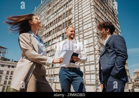 Architetti felici e di successo che lavorano insieme in un'atmosfera positiva in città, in una bella giornata di sole. Foto Stock